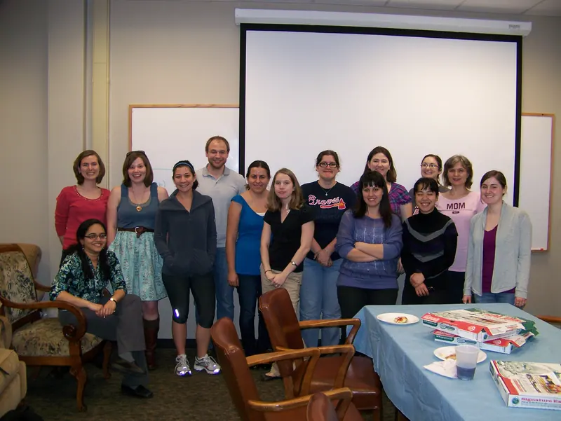 A group photo in front of the Keisler Lounge projector screen.