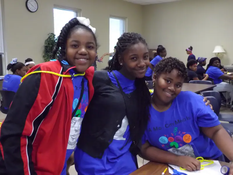 Three children pose for the camera together.