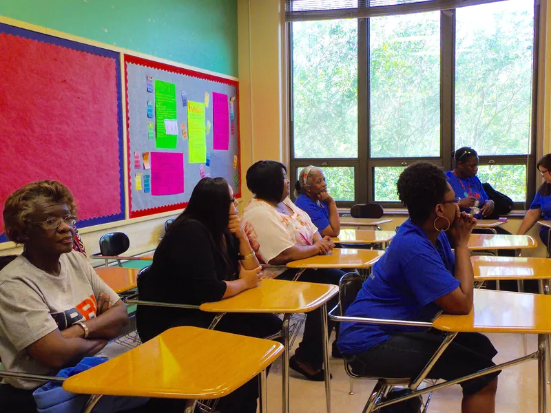 Adults sit in attendance while their children learn about mathematics.
