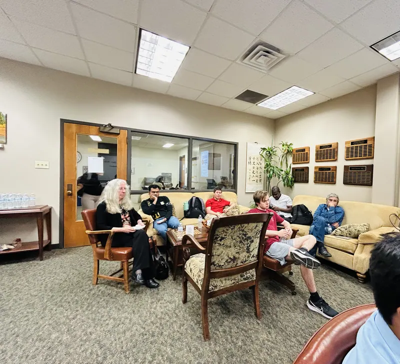 With not enough room at the table, expectant listeners fill the sofas.