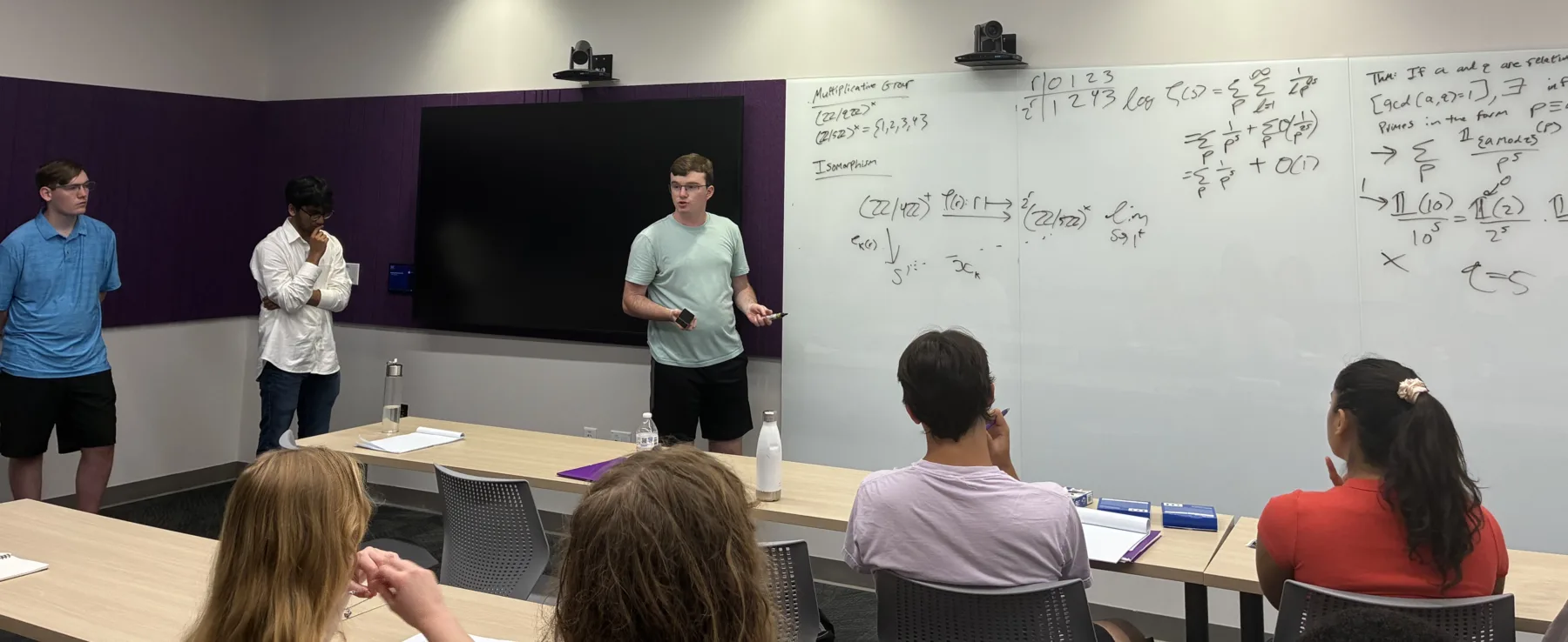 Three presenters standing at a seminar